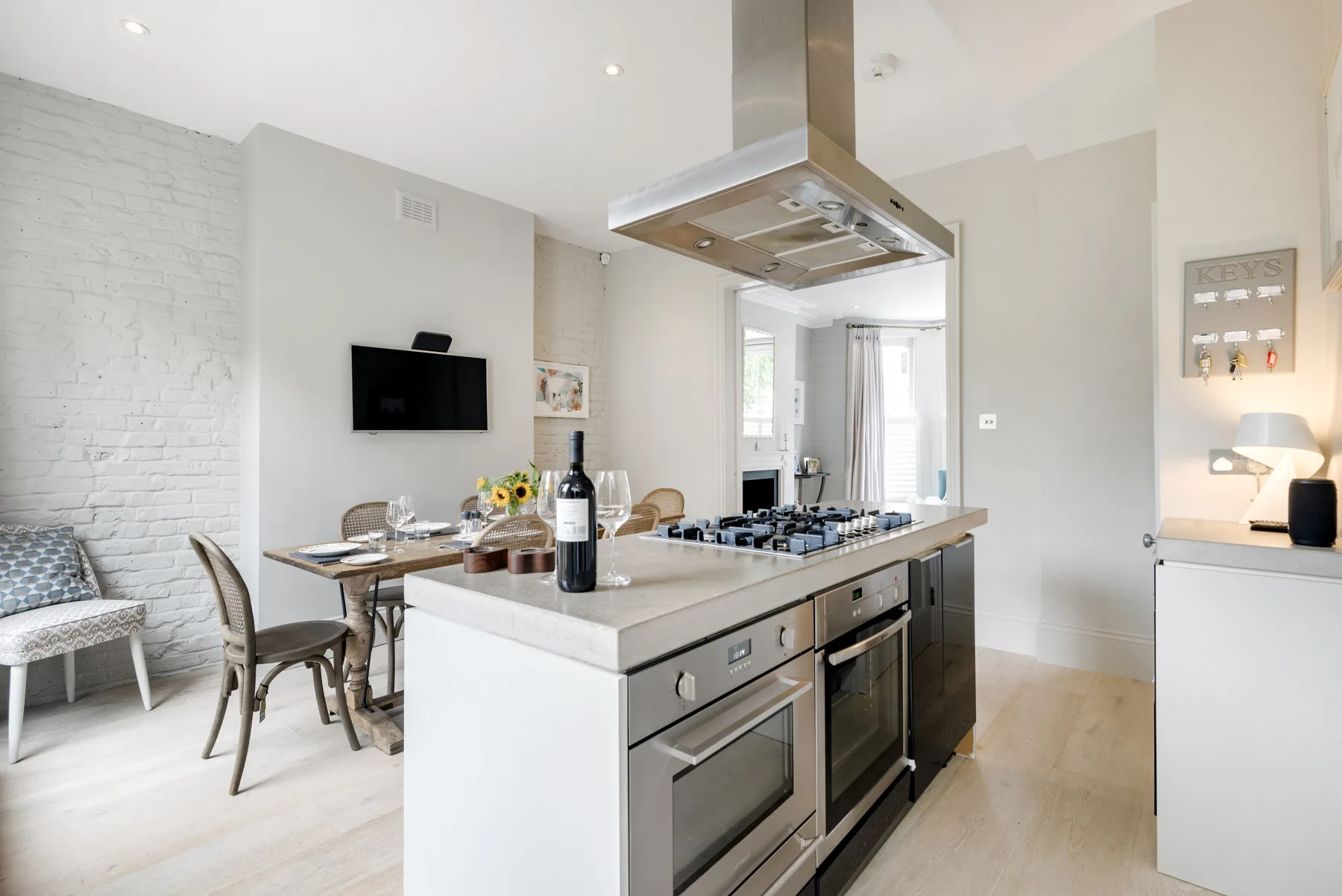 A bright open-plan kitchen and dining area with a central island and dining table.