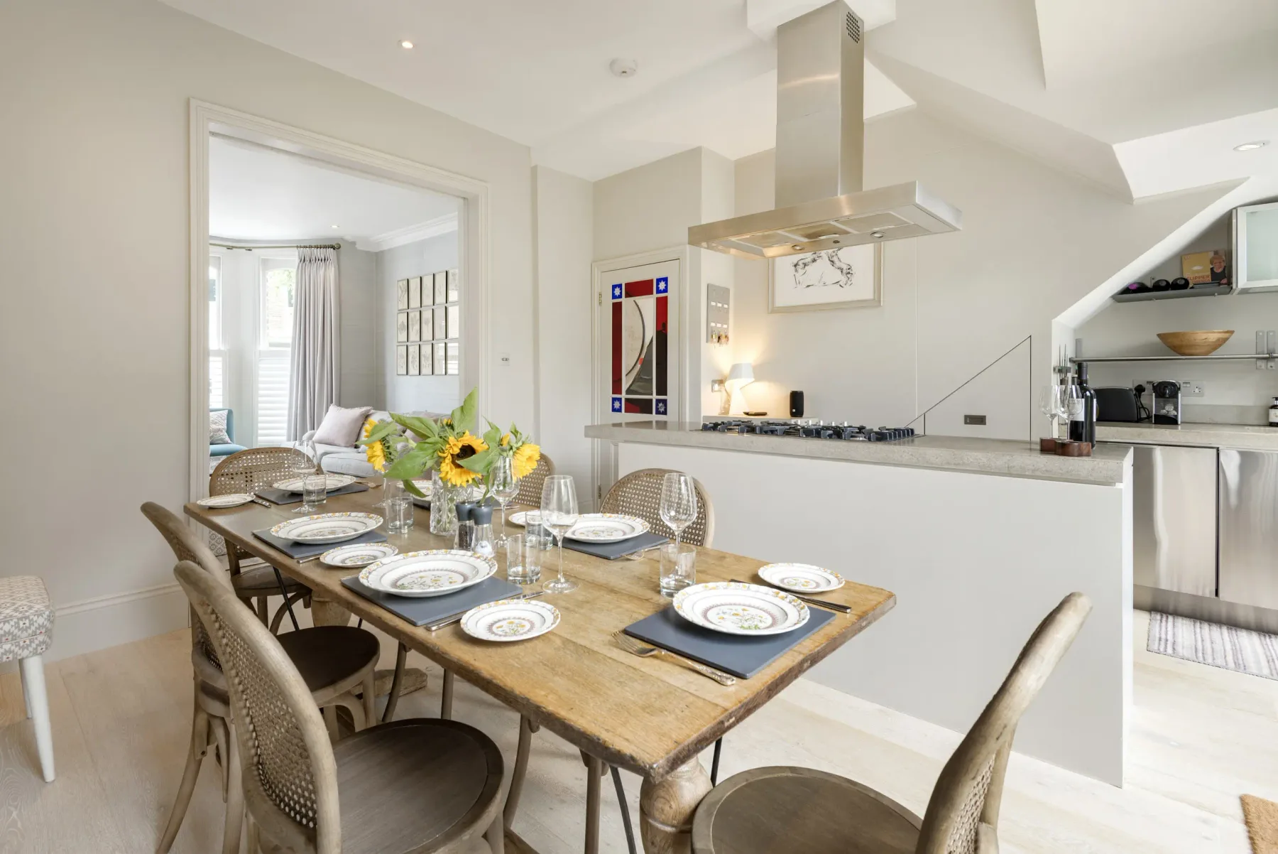 A dining area with a set table beside an open kitchen.