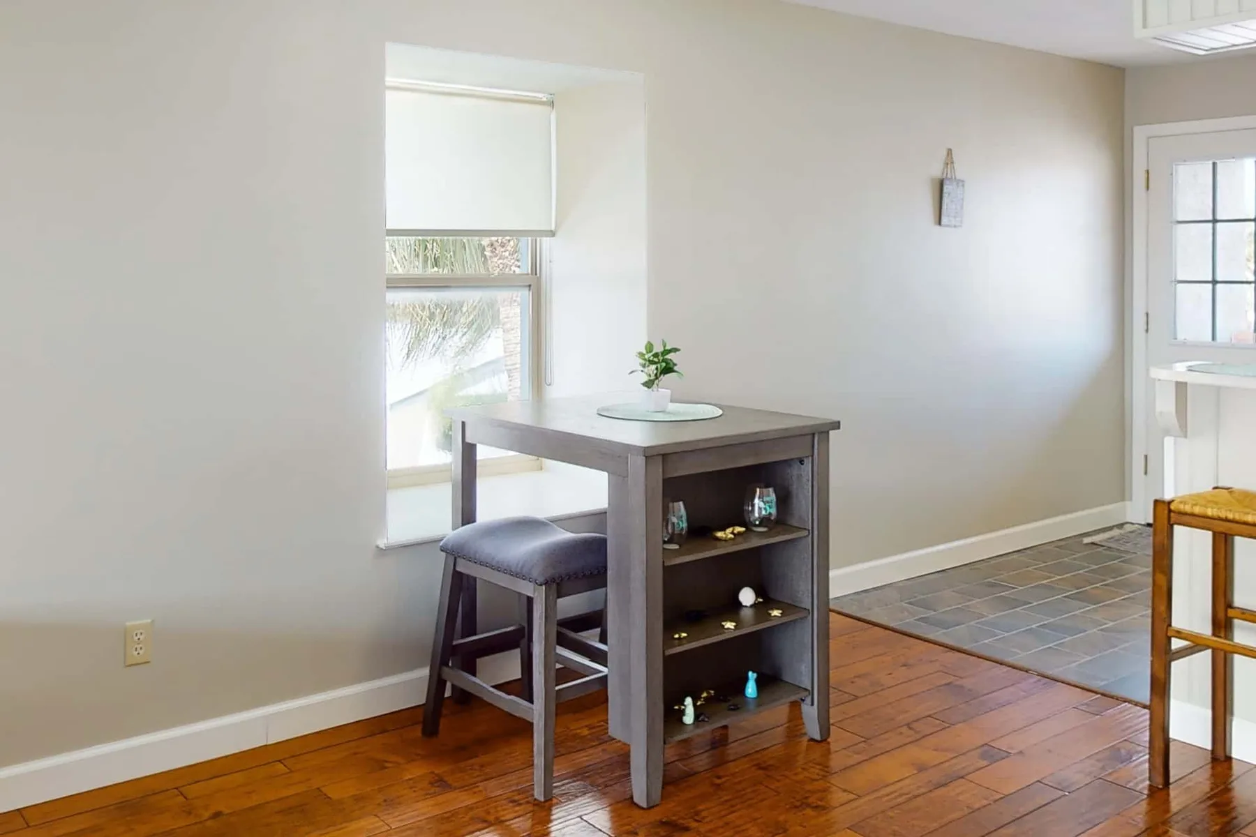 A dining area with a small table and a tiled floor section nearby.