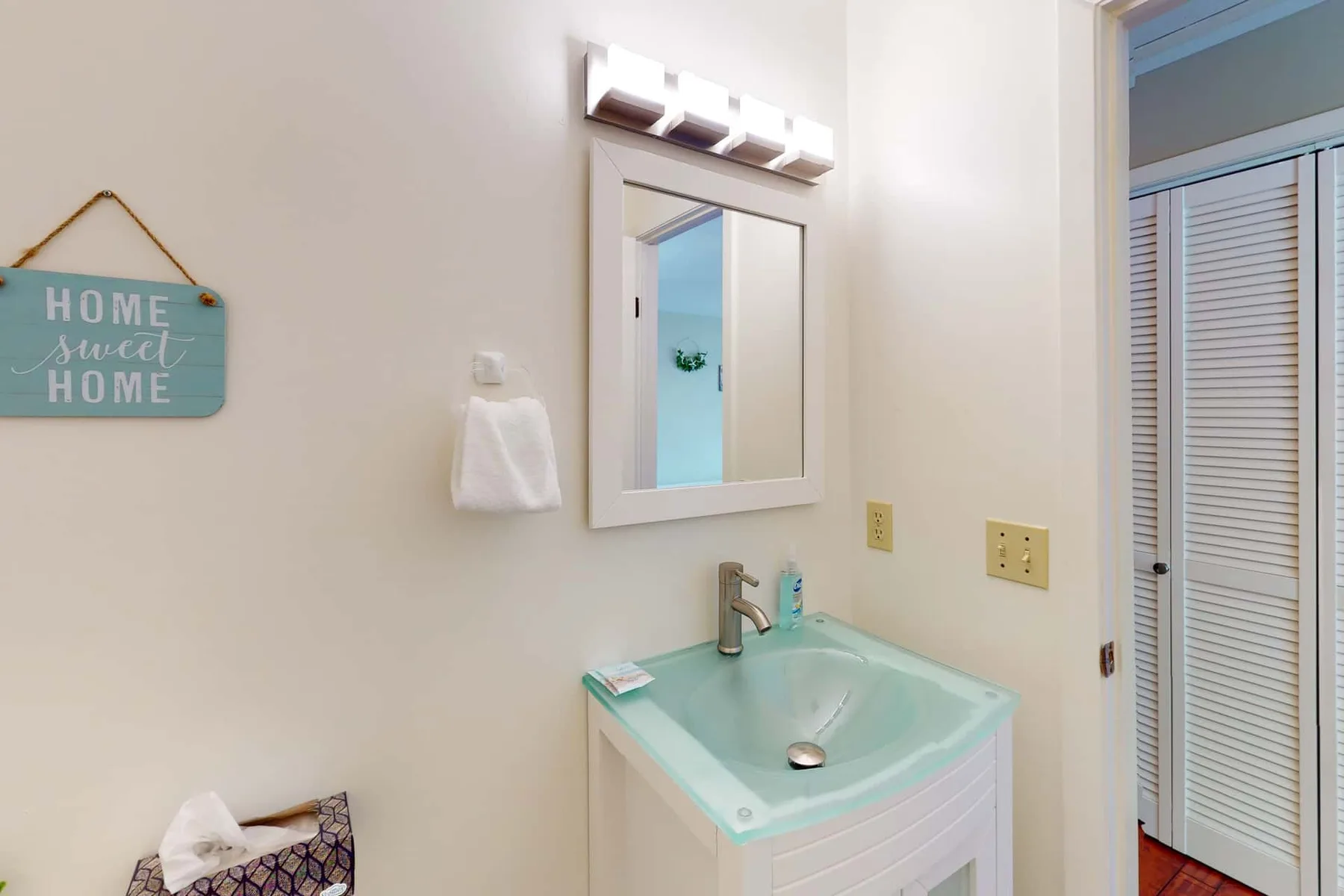 A bathroom vanity with a turquoise sink and a wall mirror.