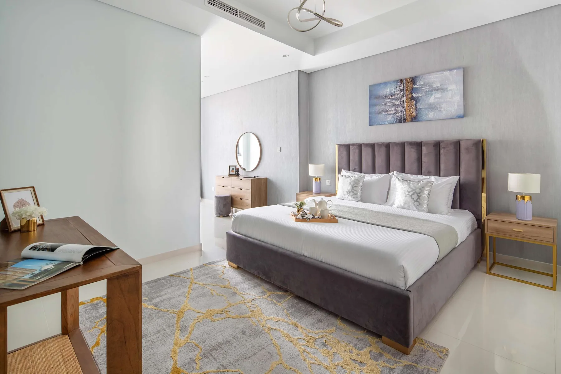 Un dormitorio con una cama grande, mesitas de noche y una alfombra estampada.