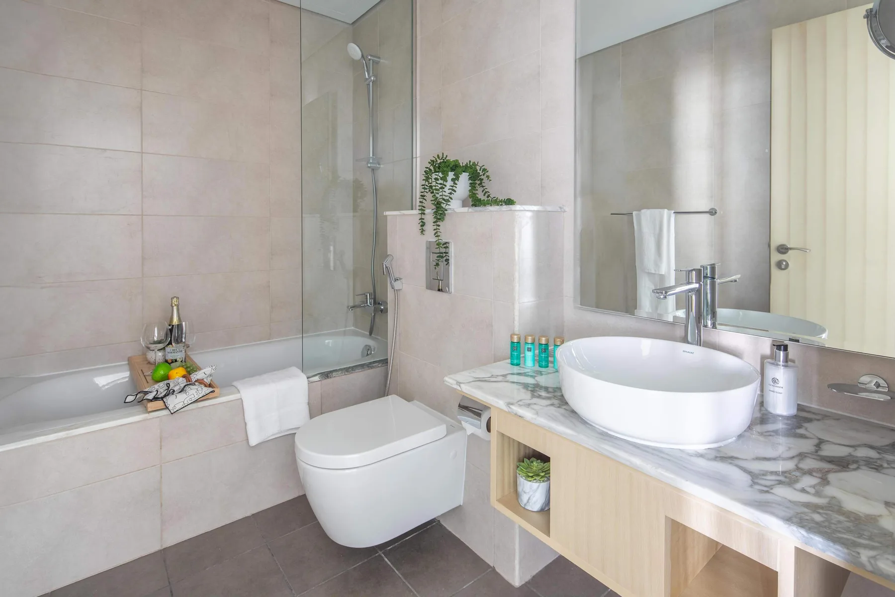 Un baño con bañera, ducha, inodoro y lavabo sobre un mueble.