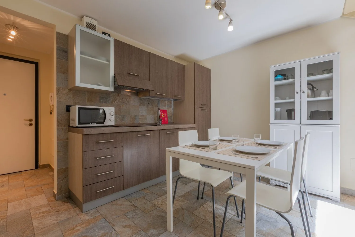 Comedor con una mesa y sillas junto a una cocina compacta.