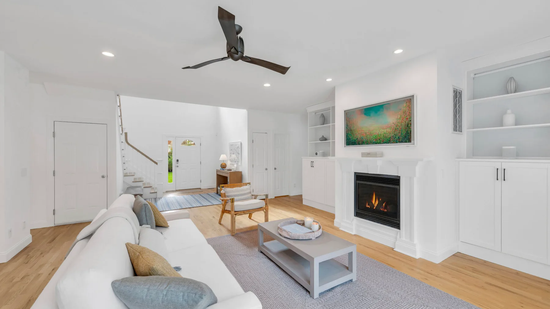 A bright living room with seating, a coffee table, and a fireplace.