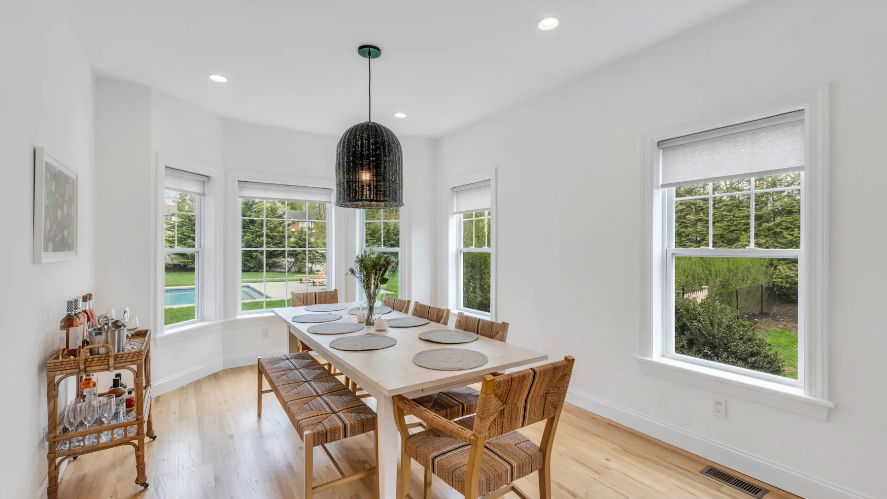 A bright dining area with a wooden table and large windows.