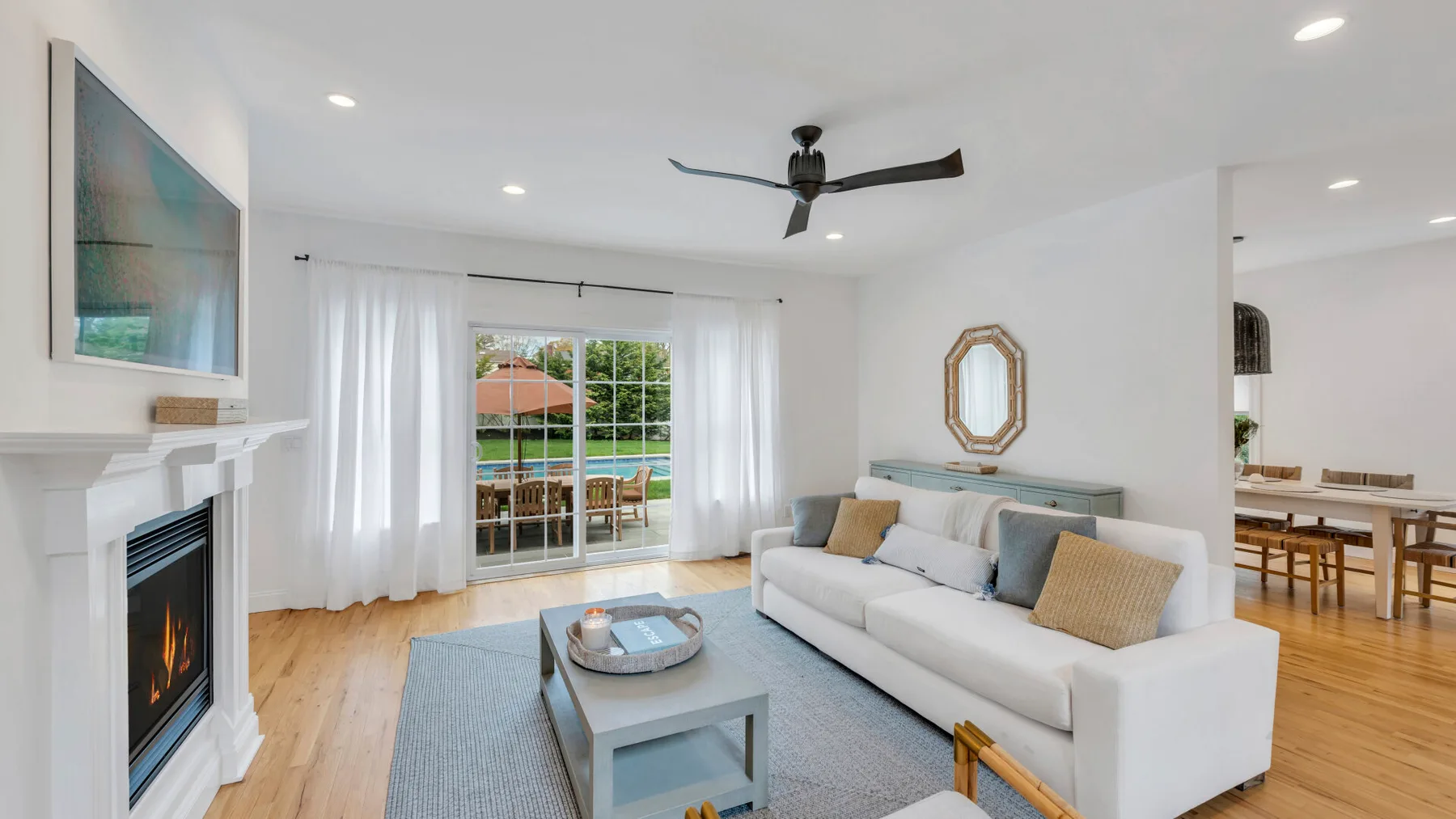 A bright living room with seating, a coffee table, and sliding glass doors.