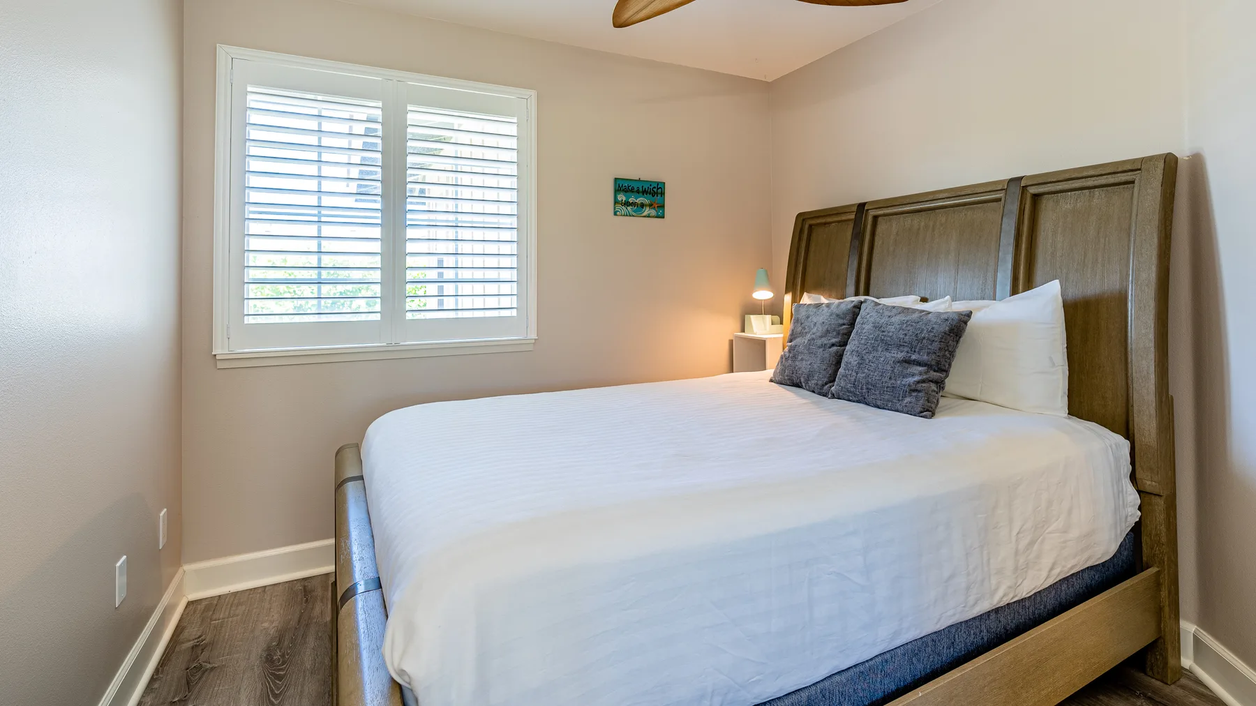 Un dormitorio con una cama bien tendida y una ventana con persianas.