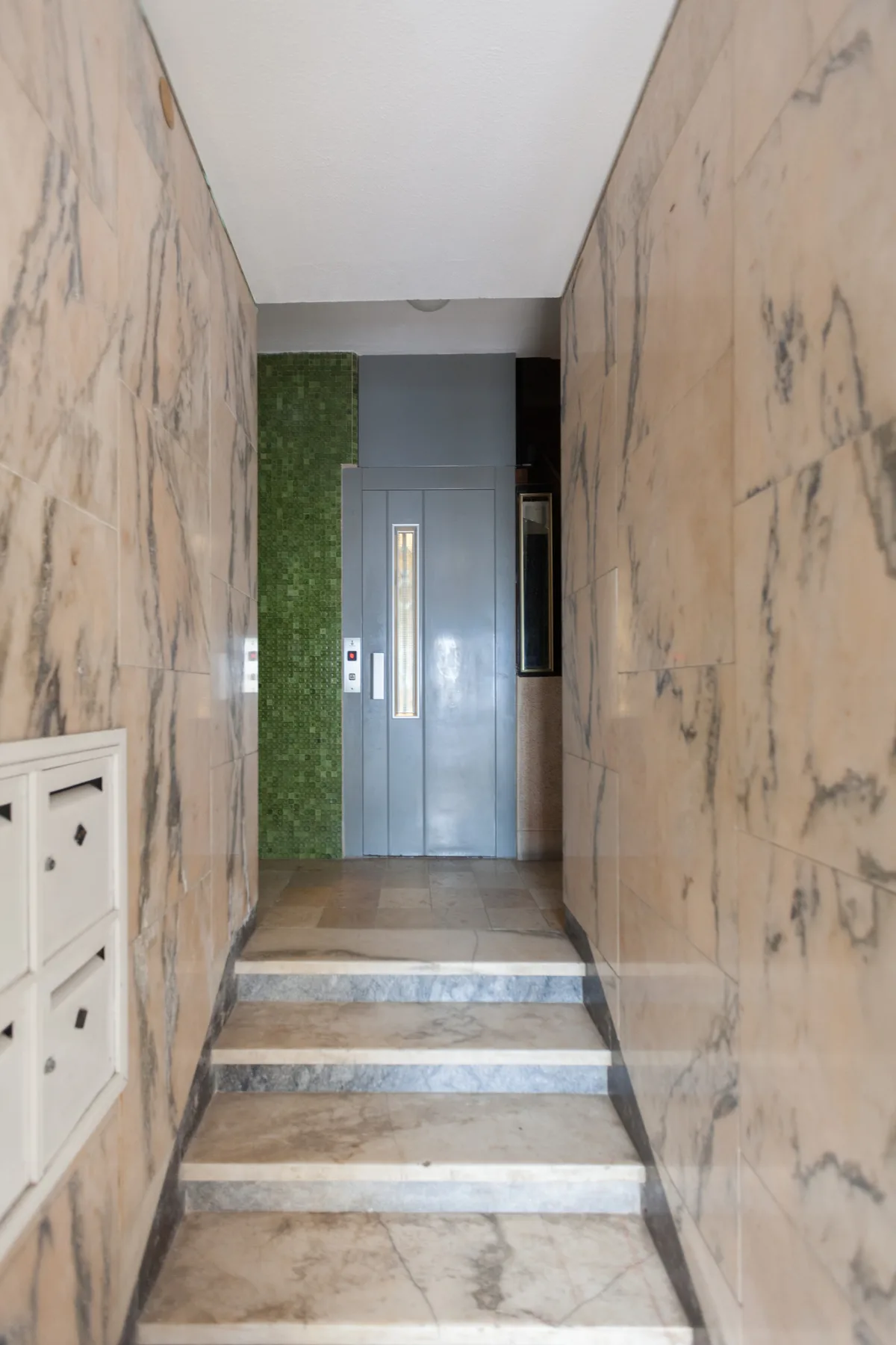 A marble-lined entry corridor leads to an elevator.