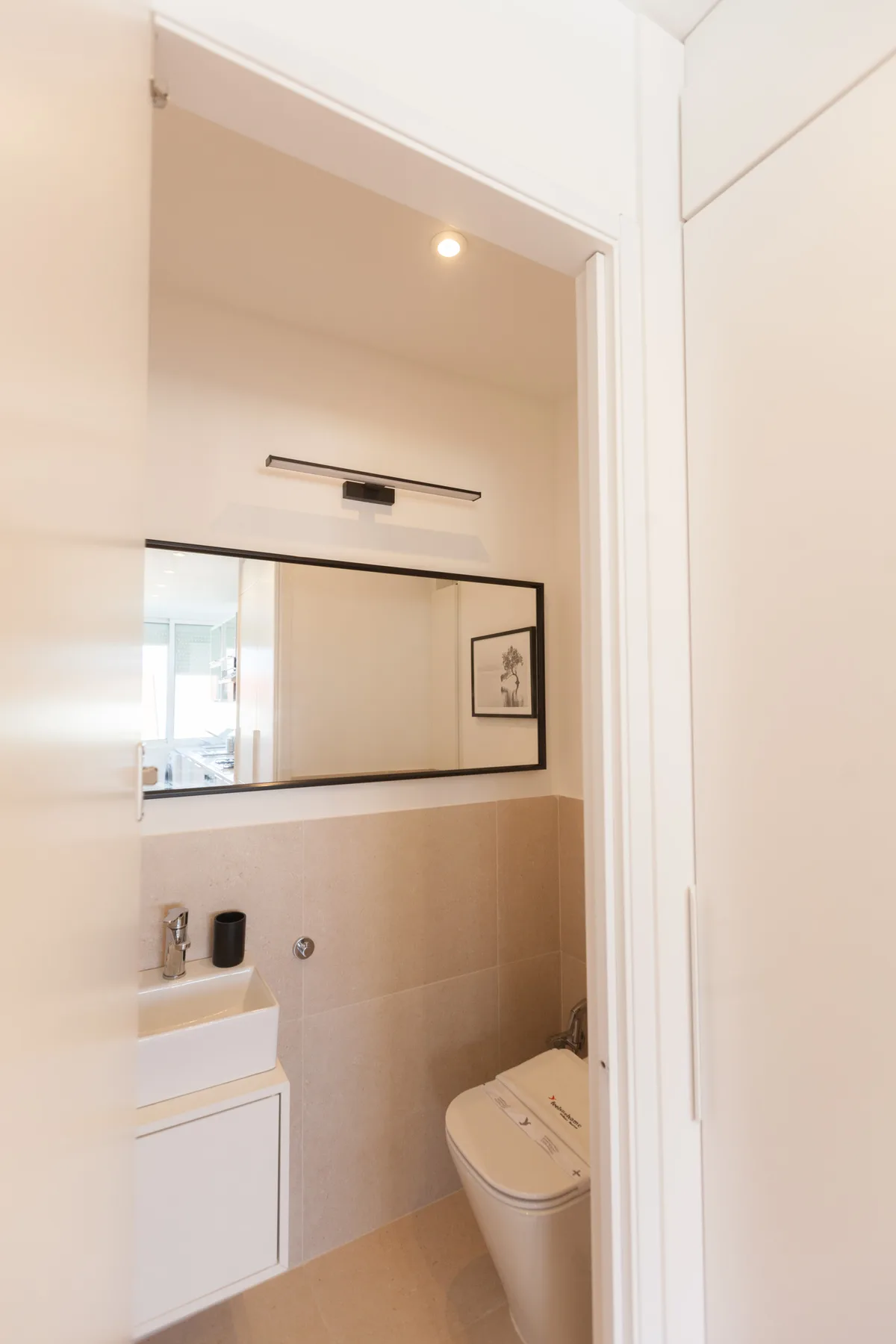 A bathroom with a sink, mirror, and toilet.