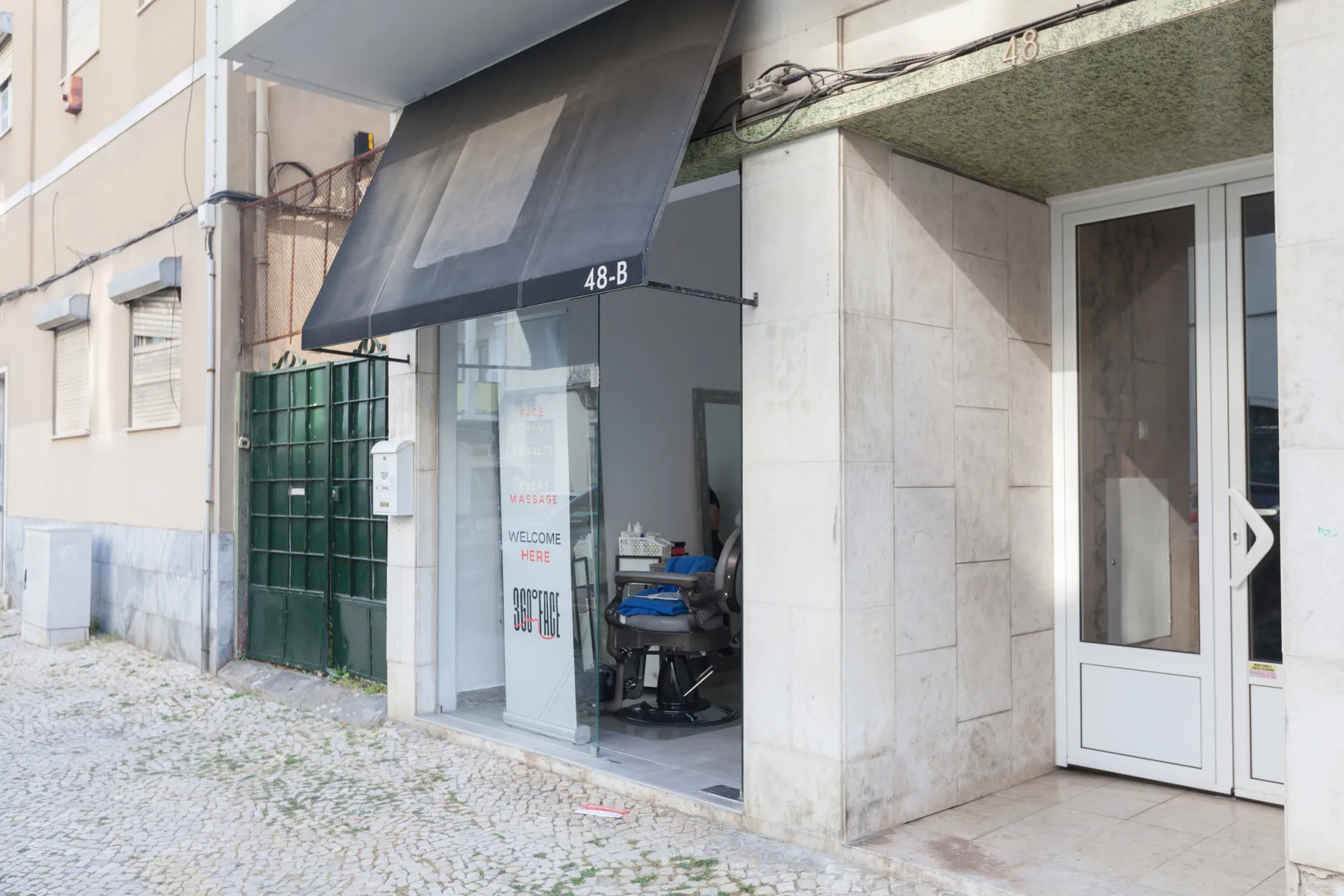 Street-level building entrance with a glass storefront and white double doors.