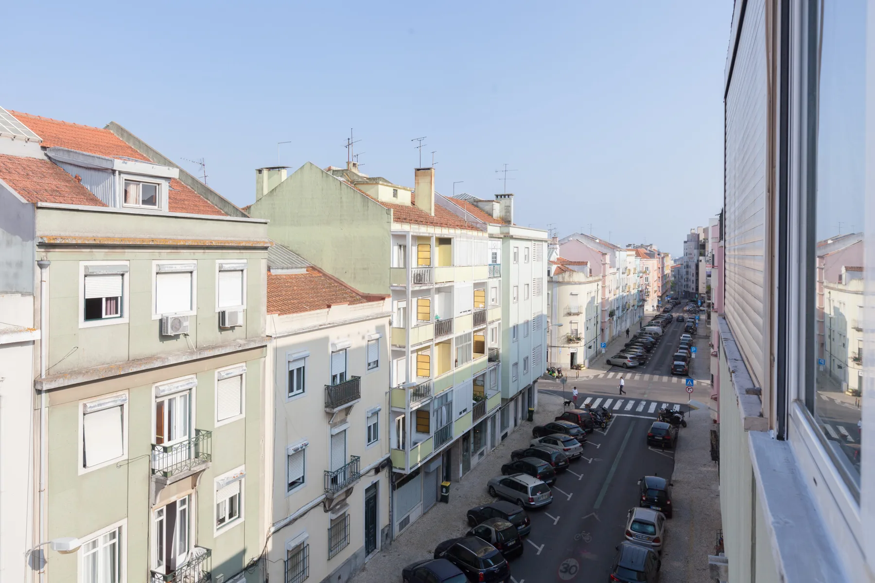 A city street lined with apartment buildings is visible from a window.