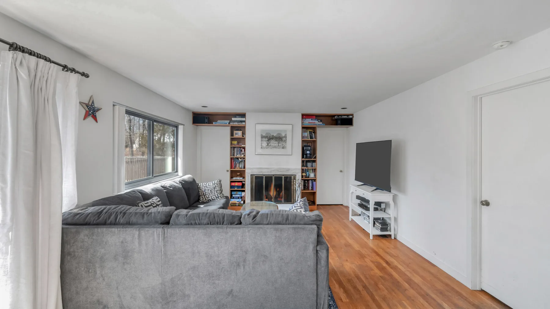 Una sala de estar con asientos, una chimenea y un televisor.
