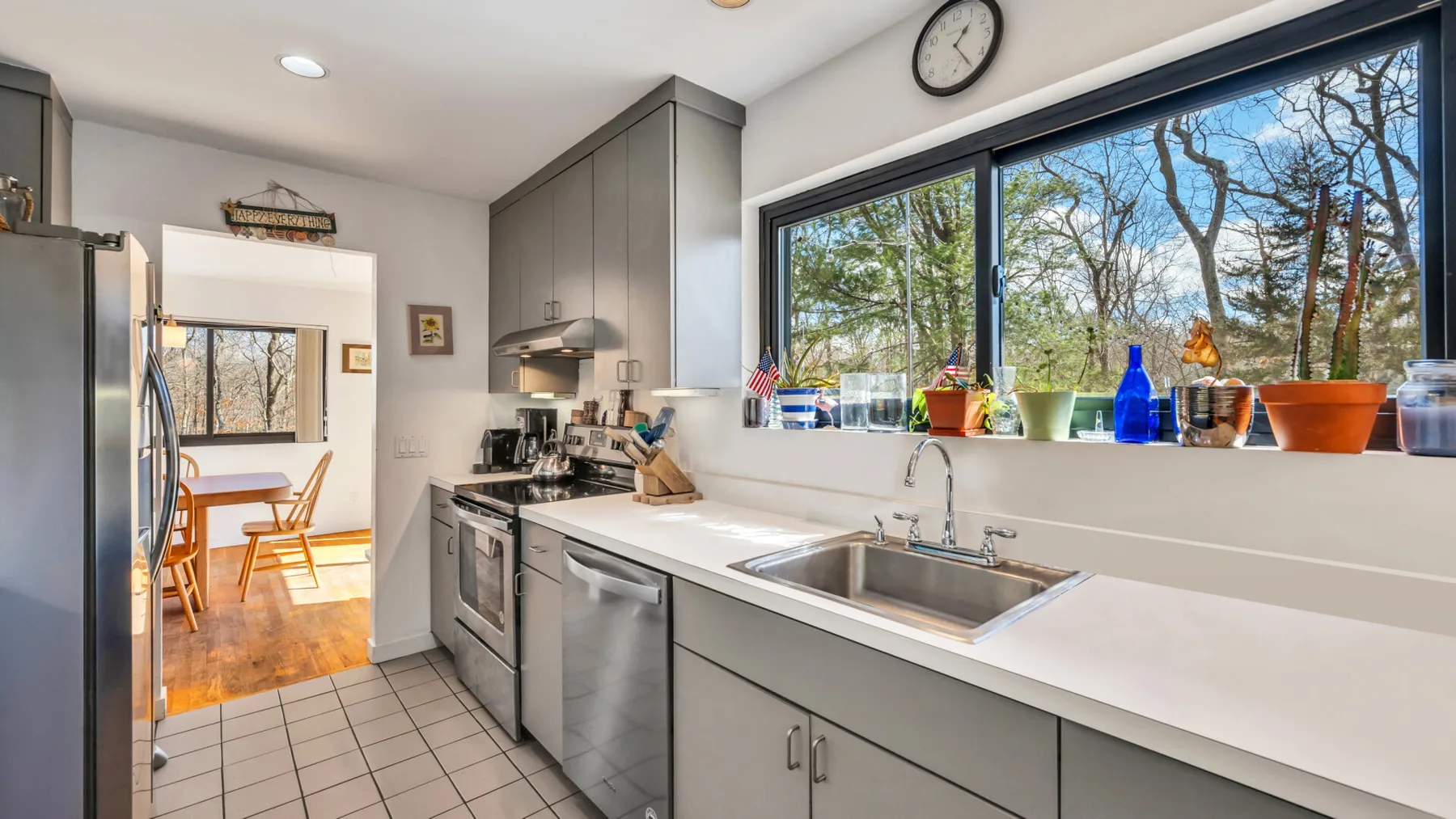 A modern kitchen with a double sink beneath a large window.