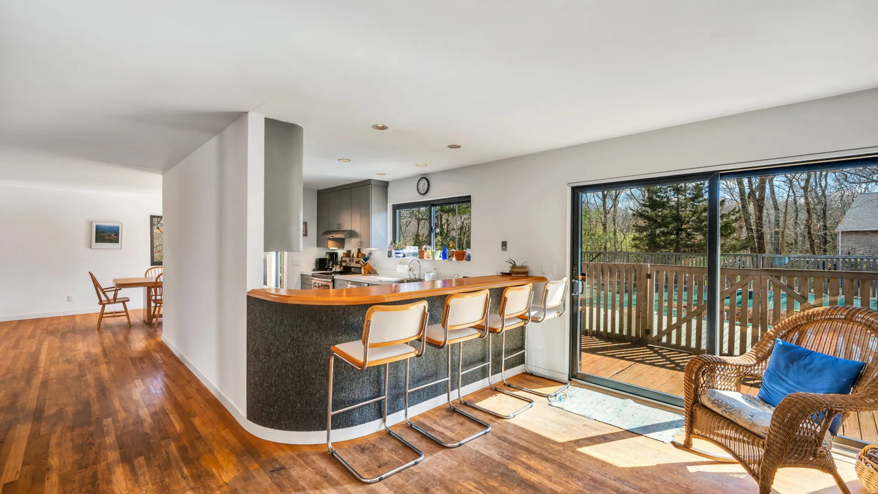 Bright open-plan kitchen and dining area with a long counter and sliding glass doors.