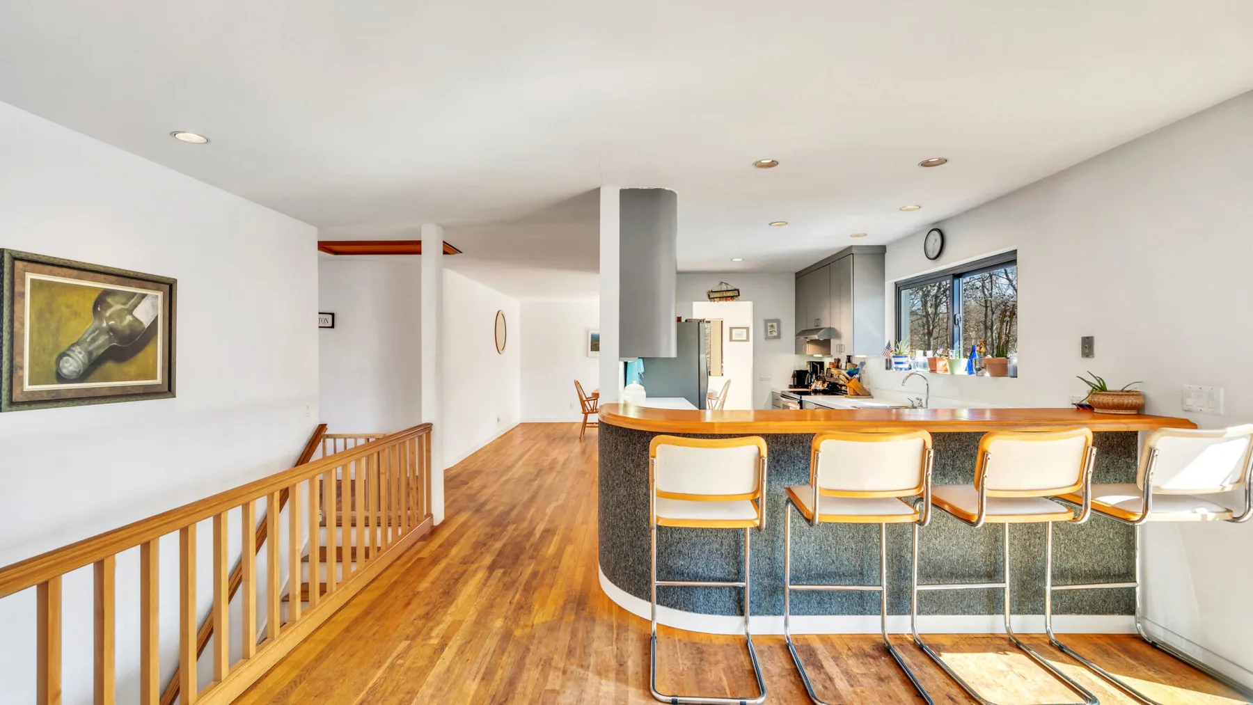 A bright open kitchen and dining area with a long counter and bar seating.