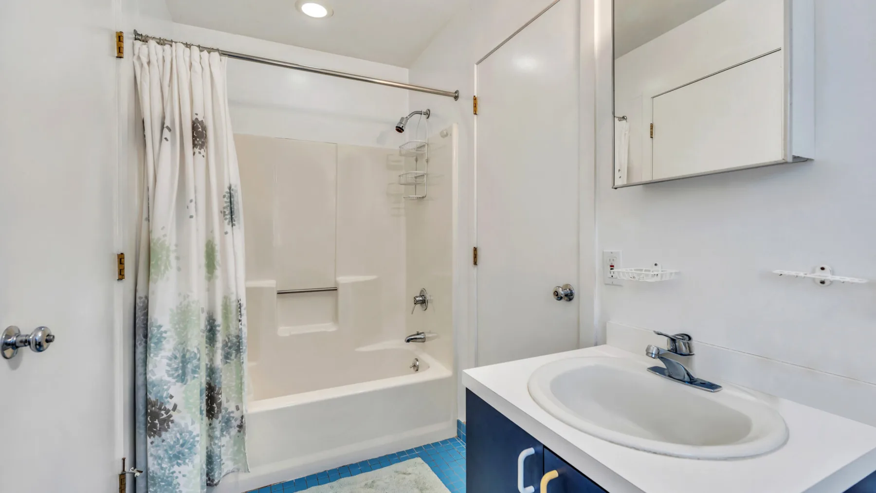 A bright bathroom with a bathtub, shower curtain, and sink.