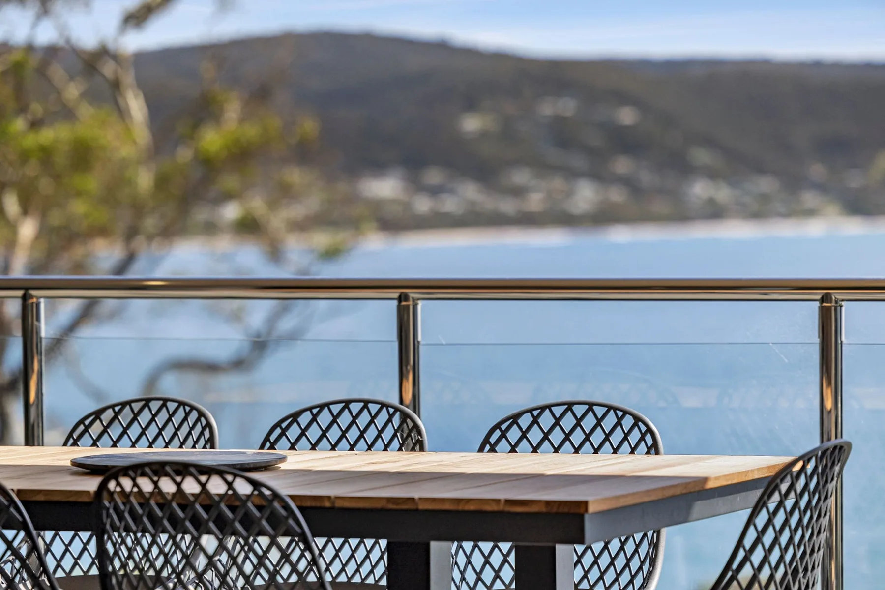 Una zona de comedor al aire libre con mesa y asientos tiene vistas al agua.