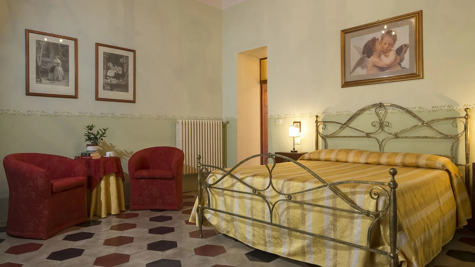 Un dormitorio con una cama cubierta de amarillo y dos sillones rojos.