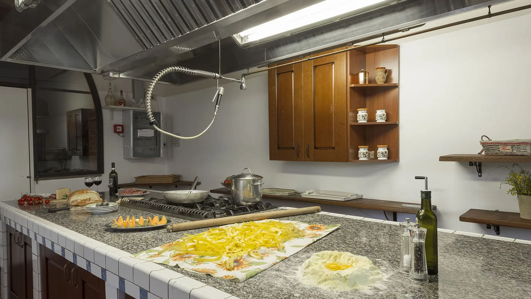 Una cocina comercial con una gran campana extractora de acero inoxidable sobre una estufa.