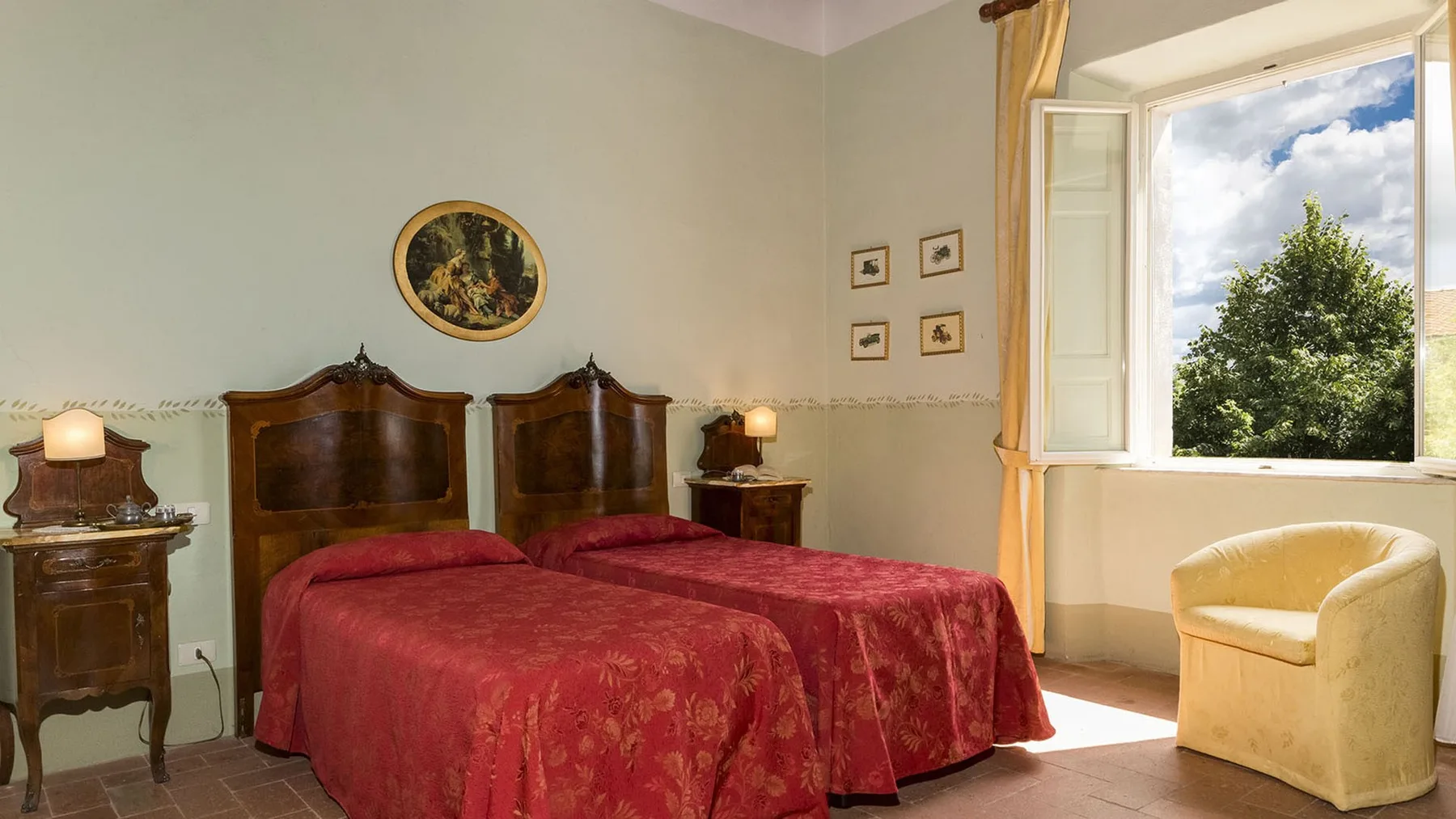 Un dormitorio con dos camas, mesillas de noche y una ventana abierta.