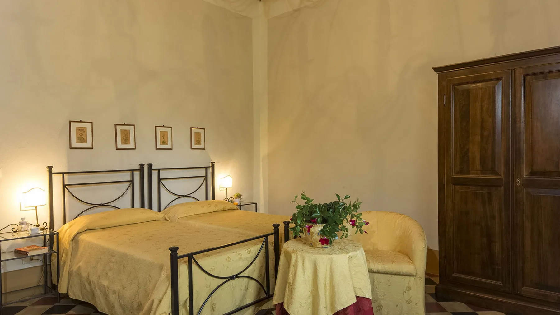 Un dormitorio con dos camas, cuadros enmarcados y un armario de madera.