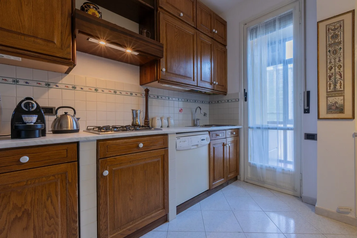 A wood-cabinet kitchen with a stove and a glazed exterior door.