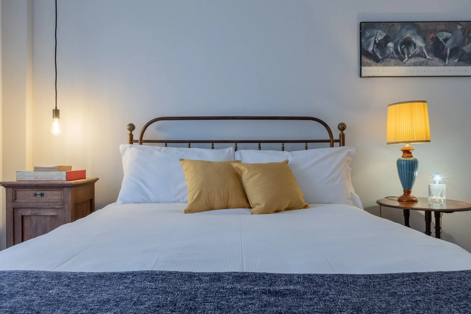 A bedroom with a neatly made bed and two bedside tables.