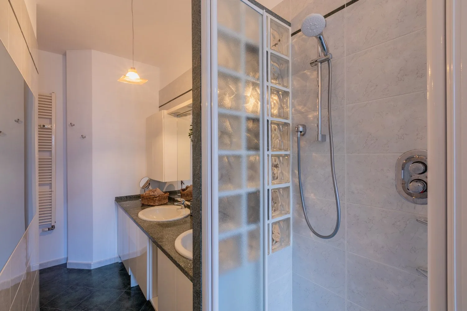 A bathroom with a glass-block shower beside a vanity.