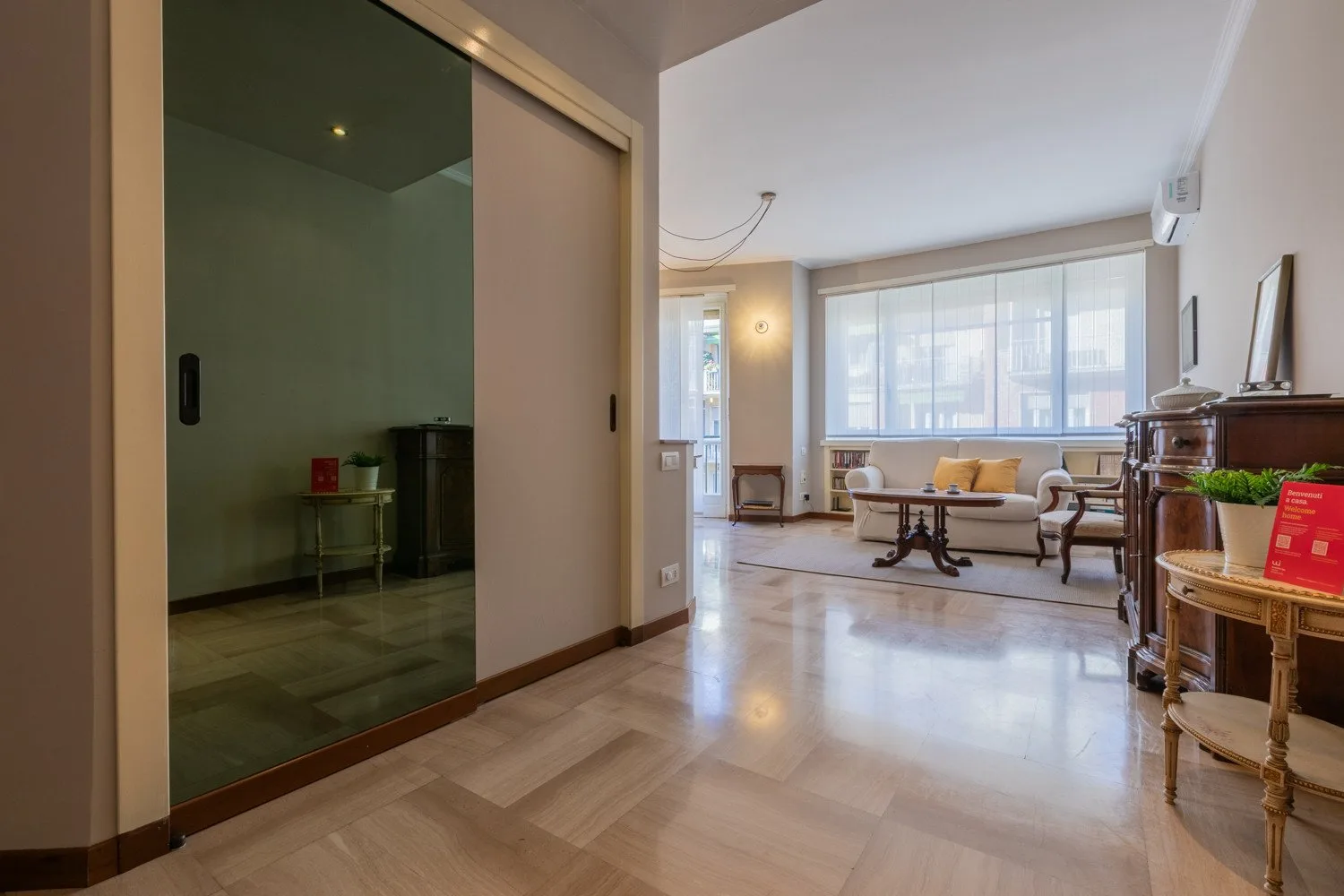 A bright living room with seating beside a wide window.
