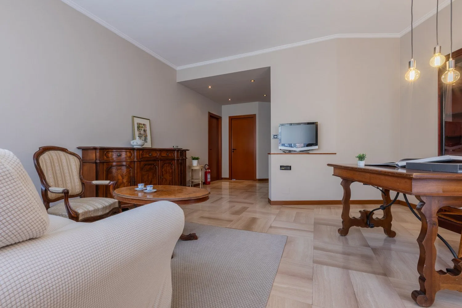 A living room with seating, a coffee table, and a television.