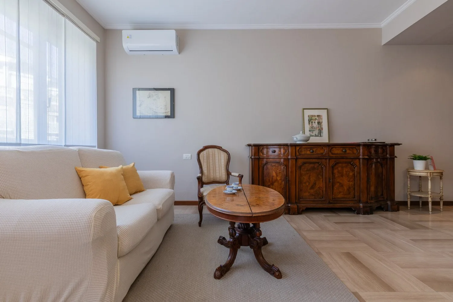 A living room with seating, a wooden coffee table, and a large sideboard.