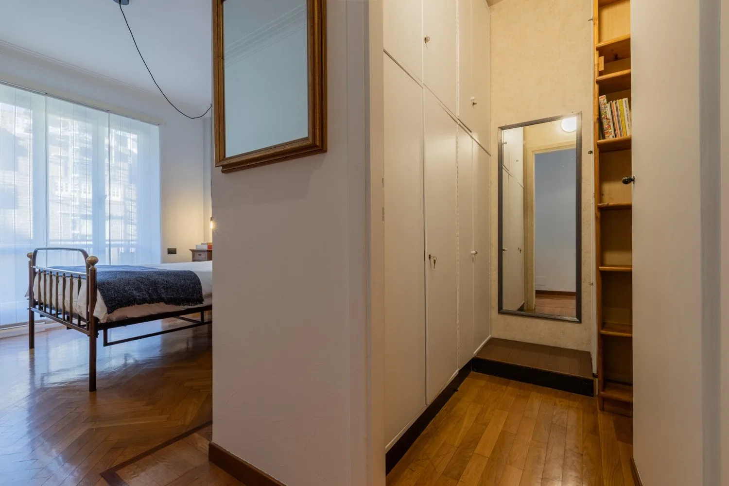 A bedroom opens onto a hallway lined with built-in storage.