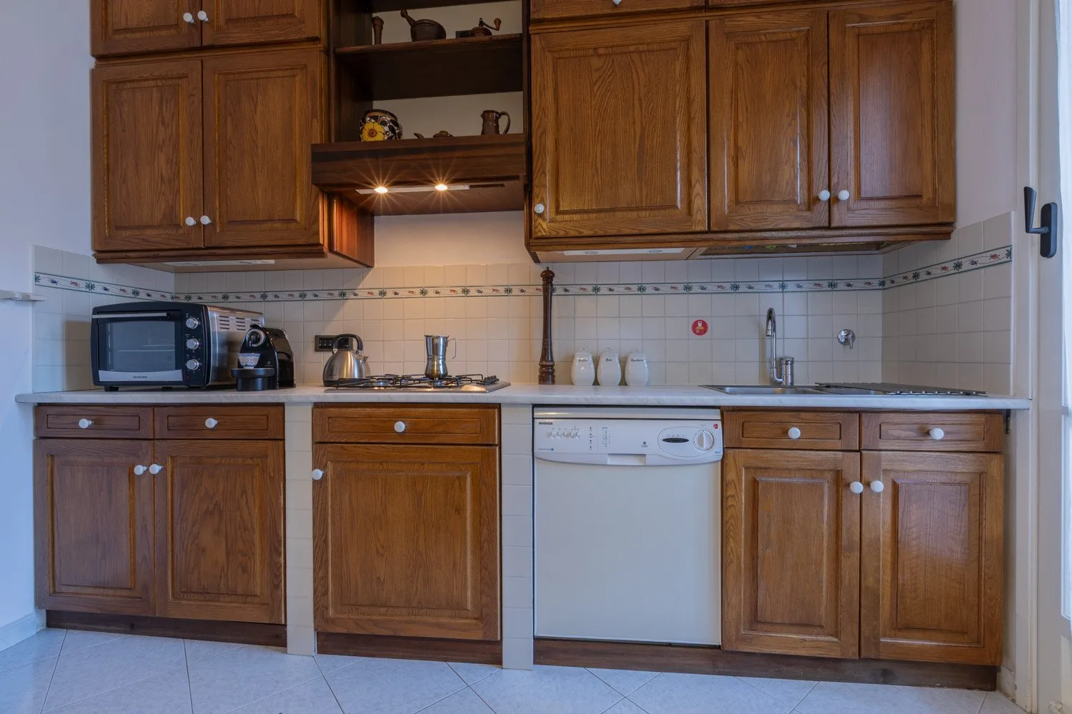 A kitchen with wooden cabinets, a countertop, and a dishwasher.