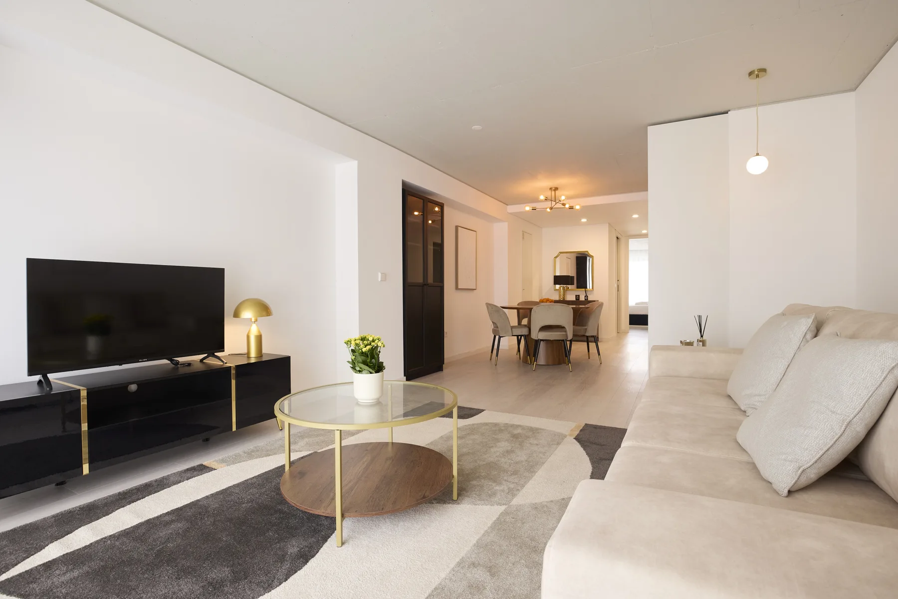 A living and dining area with a television, seating, and a round coffee table.