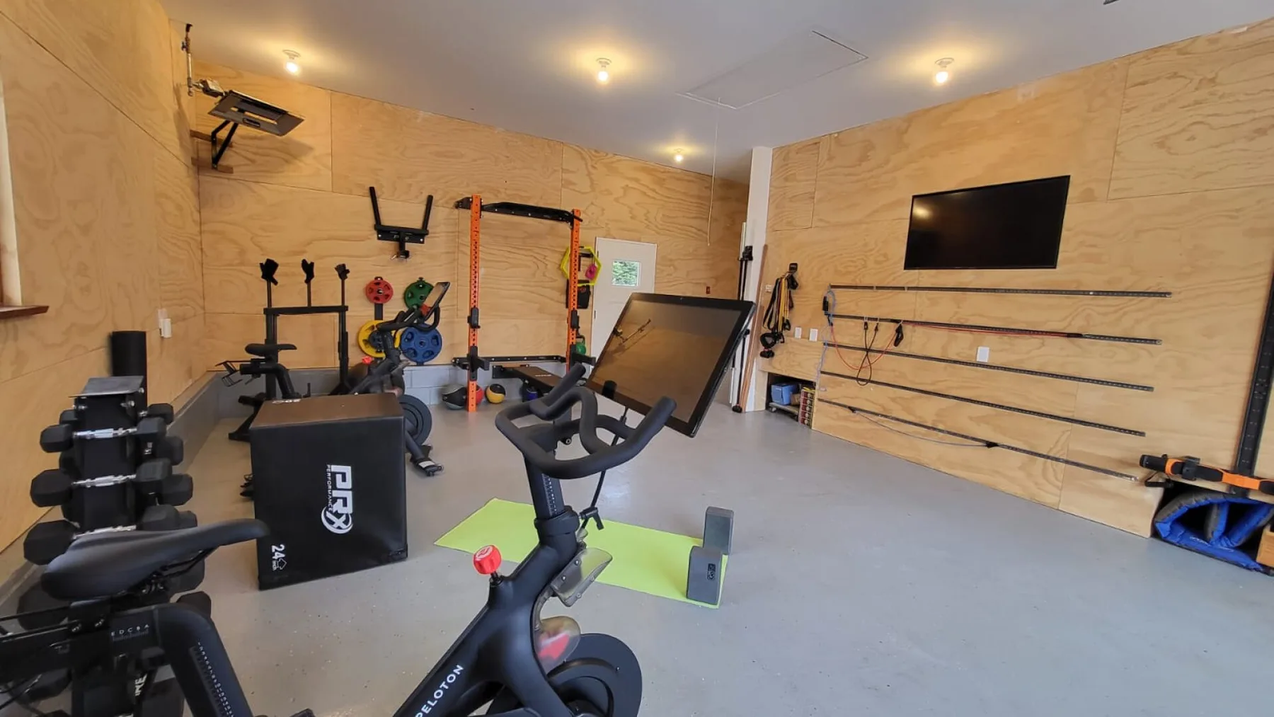 Un gimnasio en casa con bicicletas estáticas, pesas y otros equipos de ejercicio.