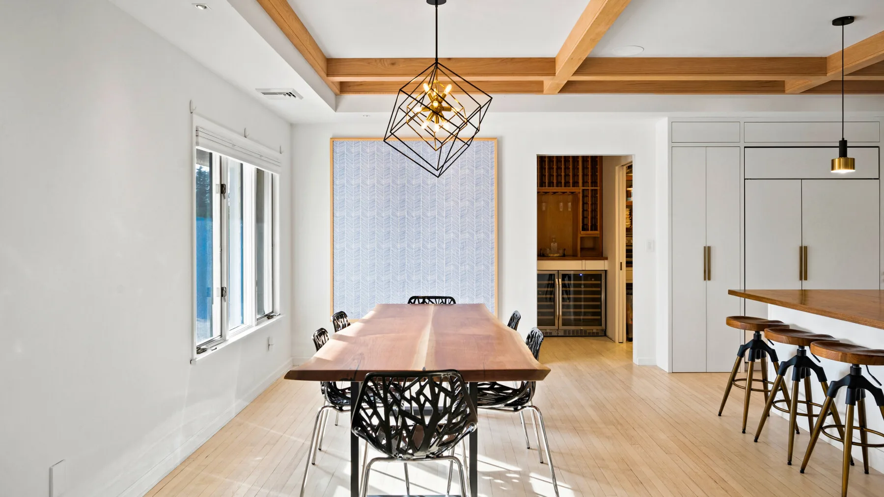 Un comedor luminoso con una mesa larga y una barra de cocina.
