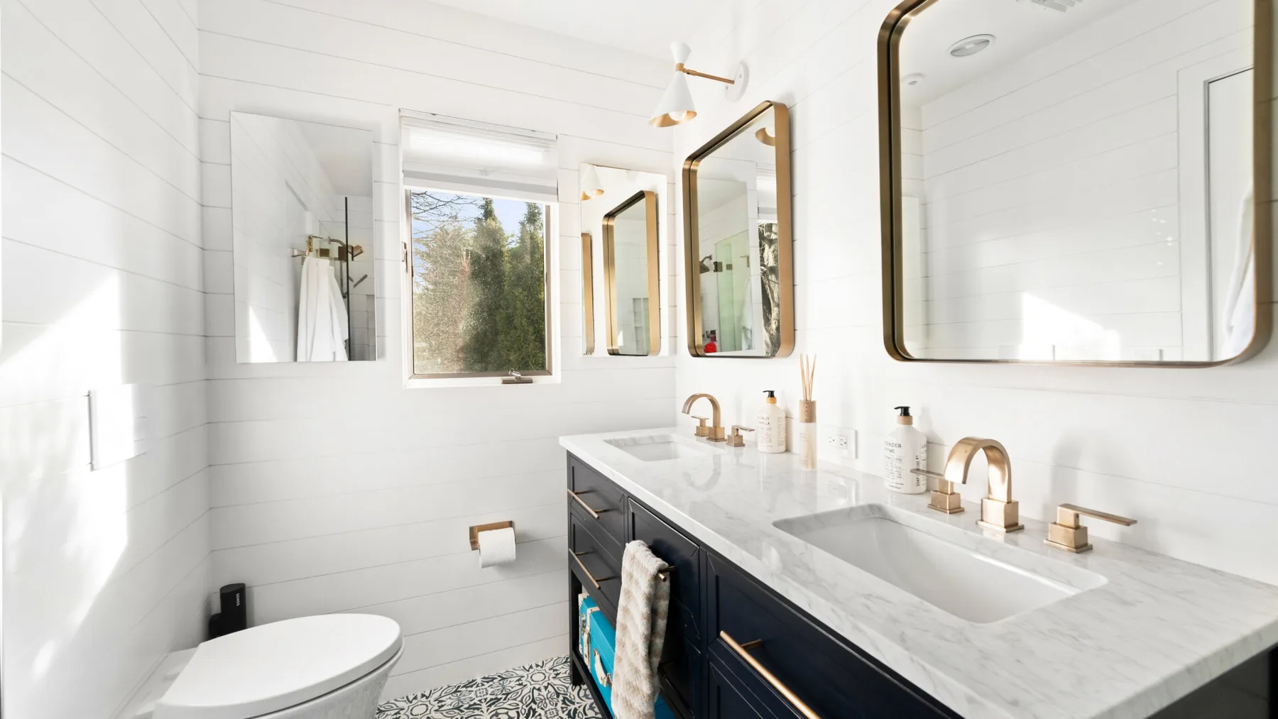 Un baño luminoso con un tocador largo, lavabo y espejos.