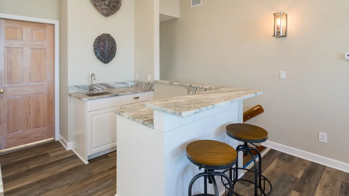 Una cocina con una isla de piedra y taburetes.