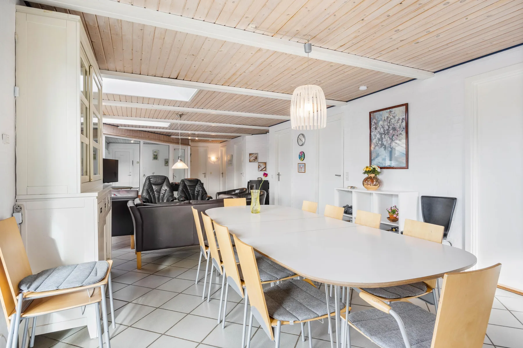 Un comedor luminoso con una mesa larga y sillas.