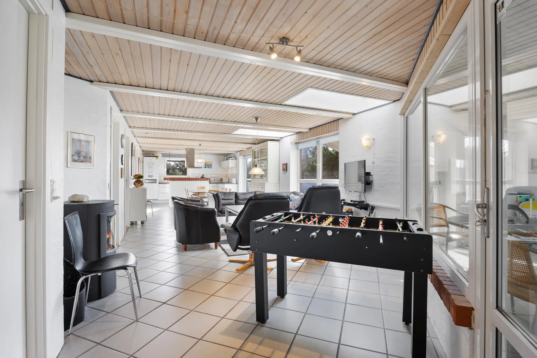 Una luminosa sala interior con asientos y una mesa de futbolín.
