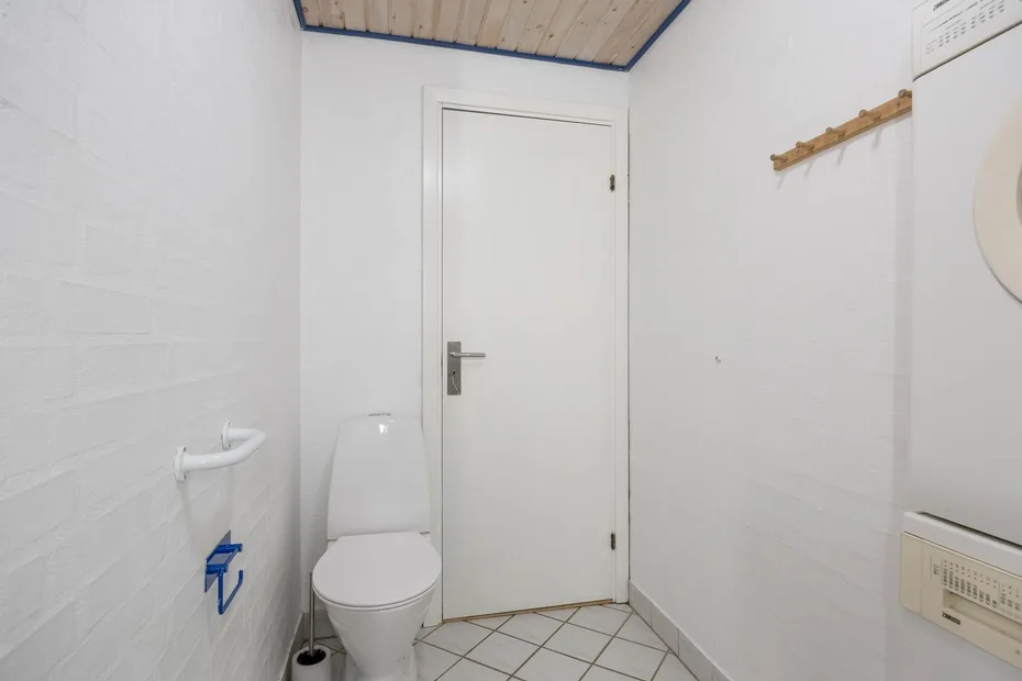 Un baño pequeño con un inodoro y una puerta cerrada.