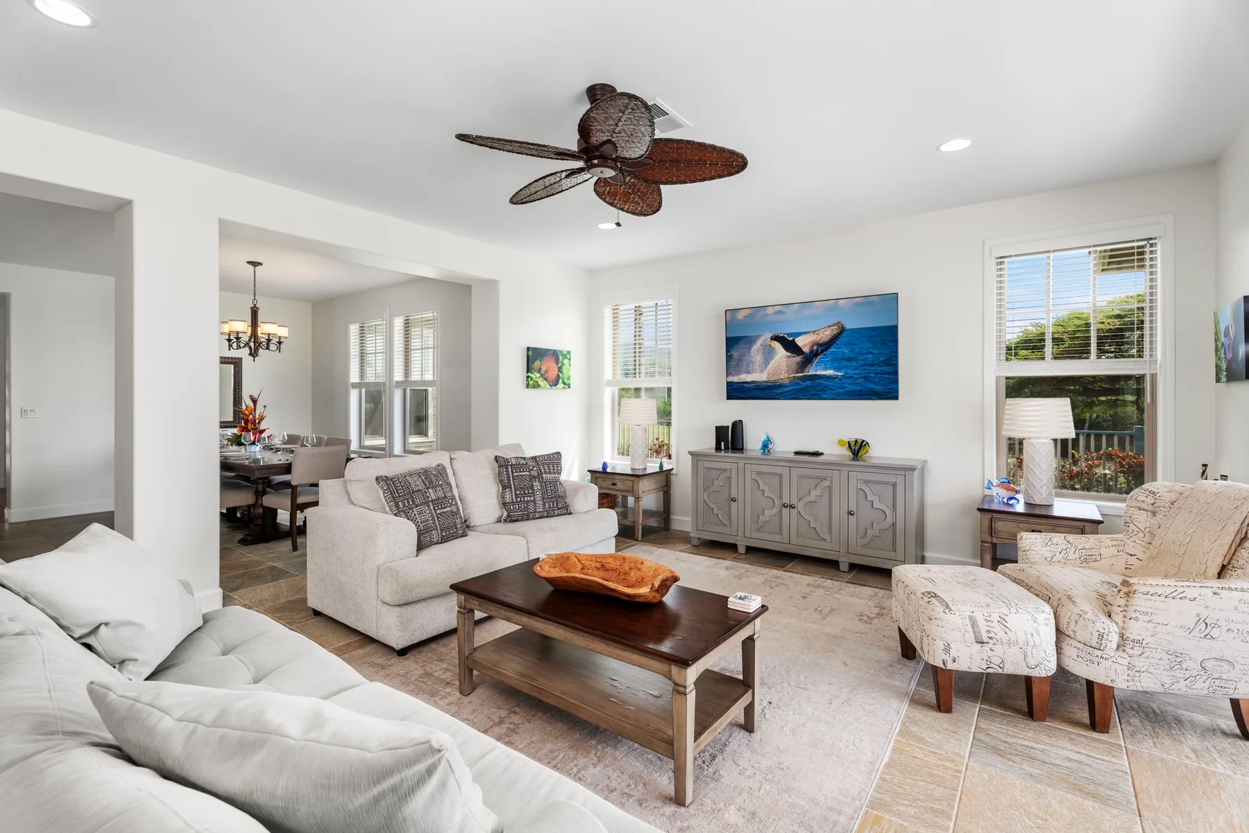 A bright living room with seating, a coffee table, and a television.