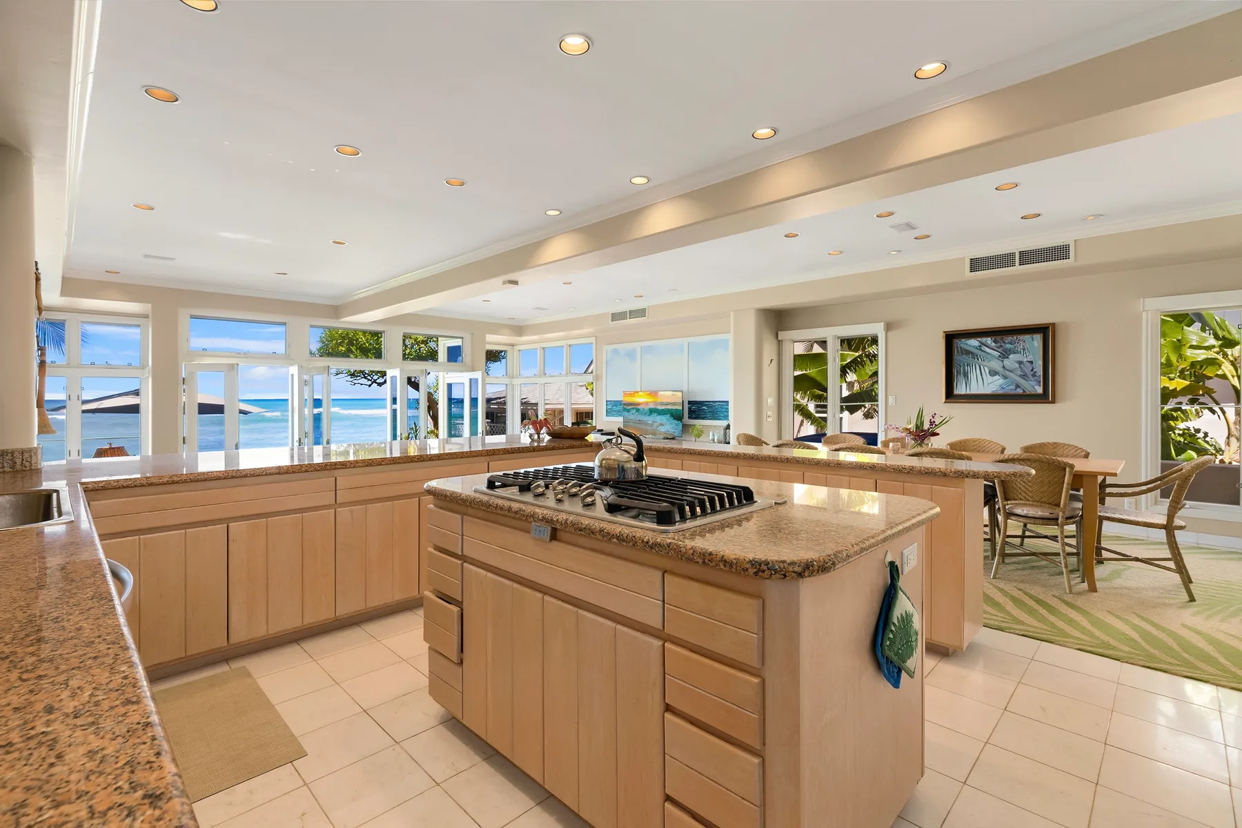 Una cocina amplia con una isla central y grandes ventanas con vista al agua.