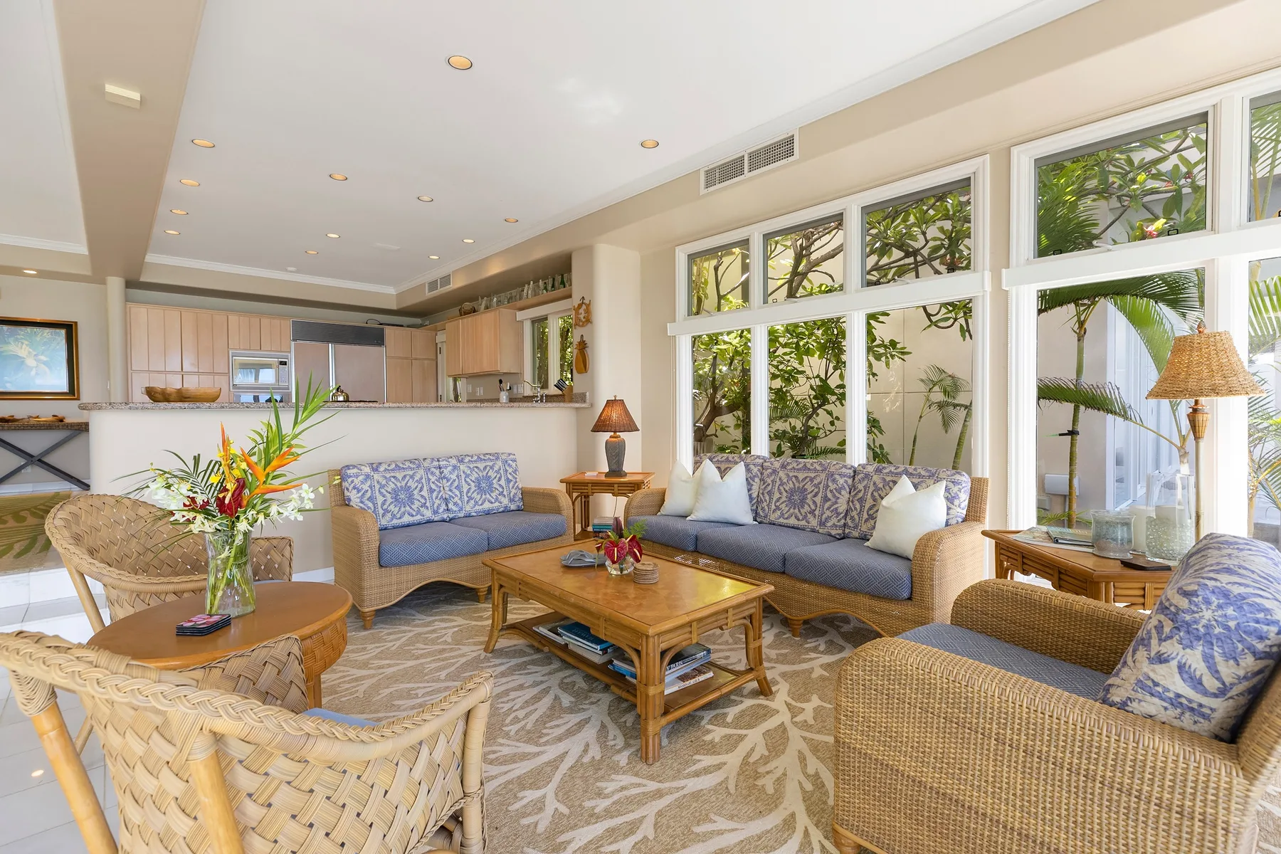 A bright living room with seating, a coffee table, and large windows.