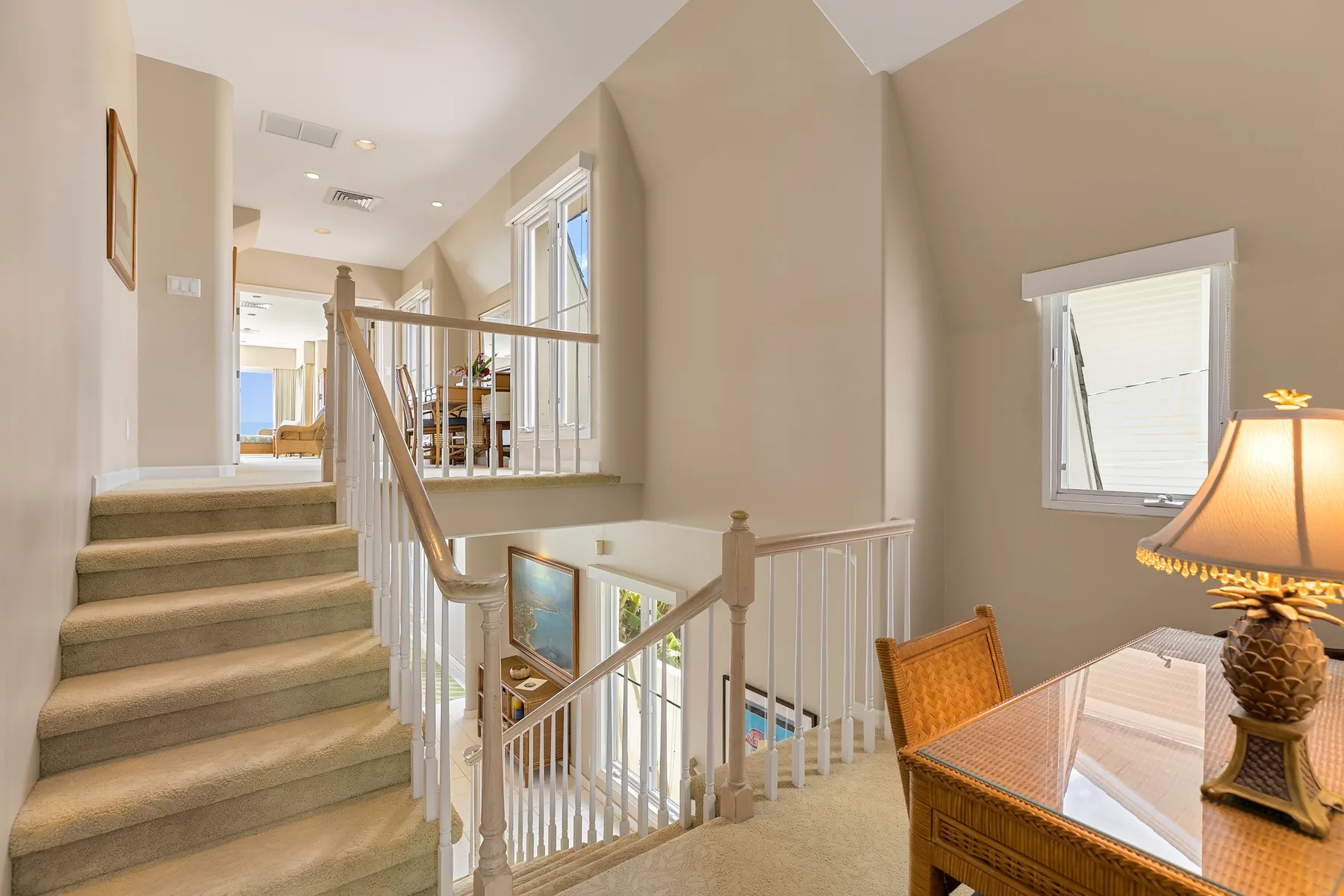 A carpeted staircase and landing overlook a bright open interior.