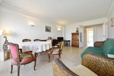 A bright living and dining room with a set table and seating.