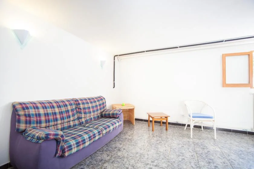 Una sala de estar con asientos a cuadros y una mesa pequeña.