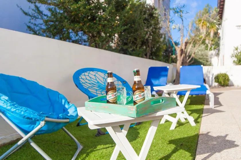 Una zona de estar al aire libre con sillas azules y una mesa baja.