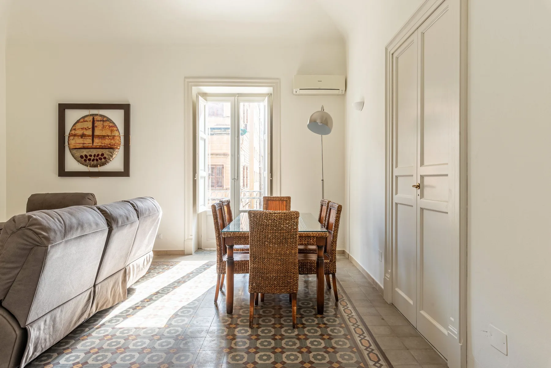 Un comedor luminoso con una mesa y asientos junto a una ventana soleada.