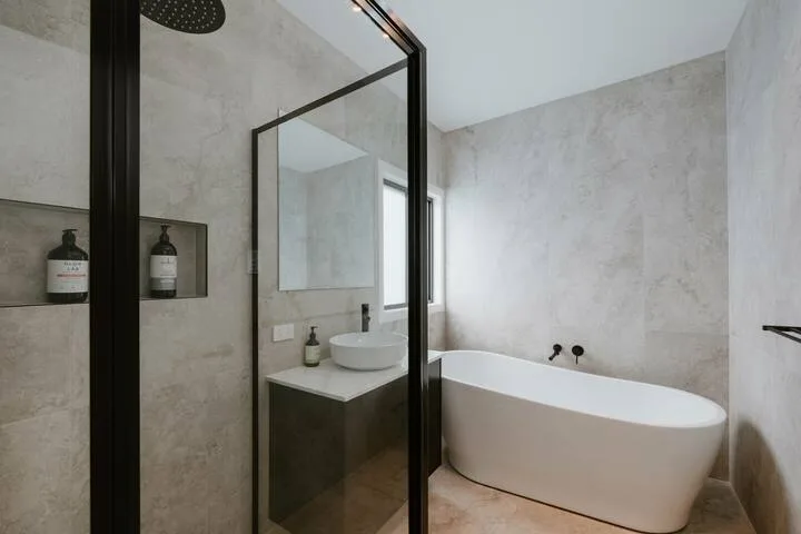 A modern bathroom with a freestanding bathtub and a sink.